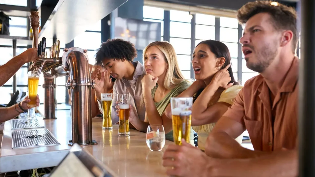 Fans verweifeln an einer Bar und trinken Bier
