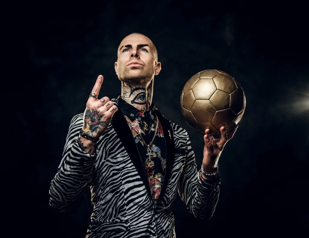 Ein Fußballspieler posiert mit dem goldenen Ball