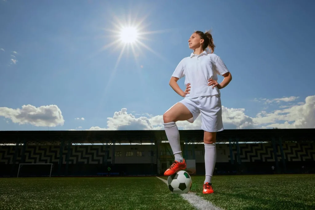 Eine Fußballspielerin posiert auf dem Trainingsplatz