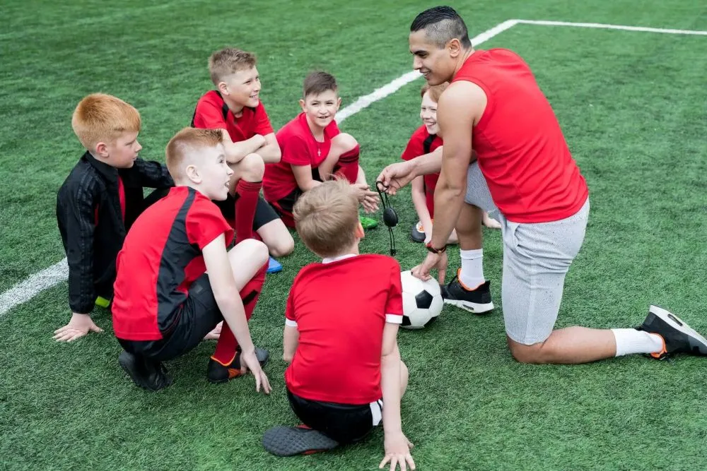 Ein Trainer gibt jungen Fußballern Anweisungen