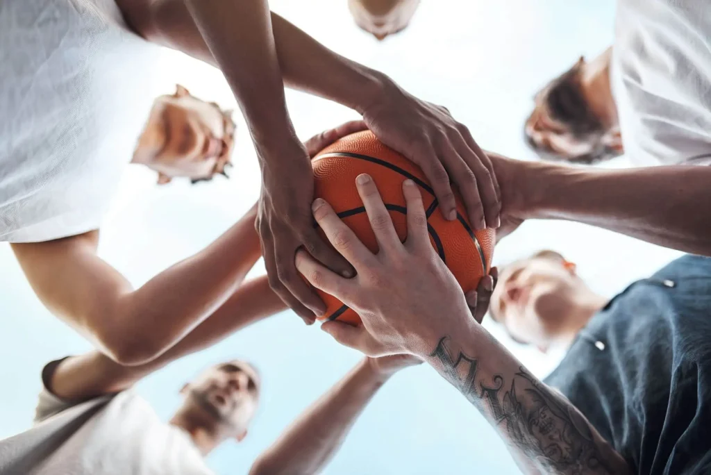 Basketballspieler halten einen Ball zusammen