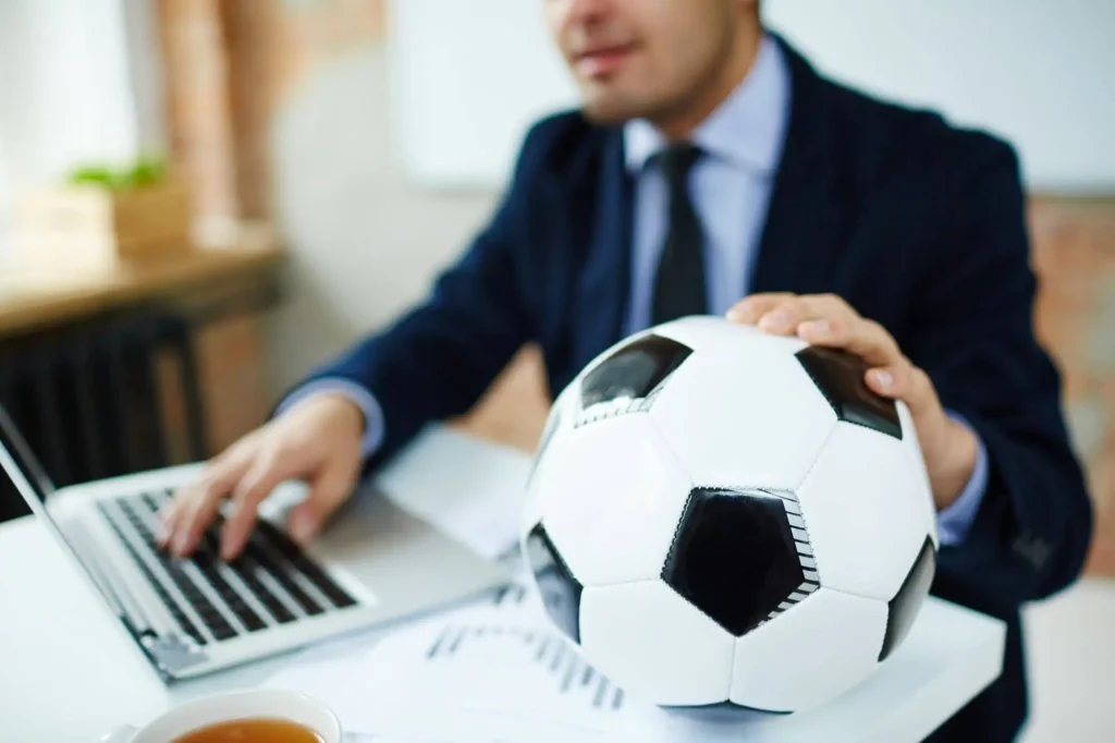 Ein Manager überprüft die Finanzen eines Vereins mit Ball in der Hand