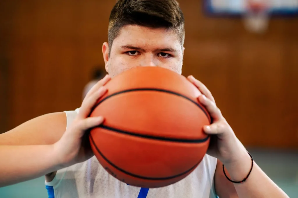 Ein Basketballspieler mit Ball vor dem Gesicht