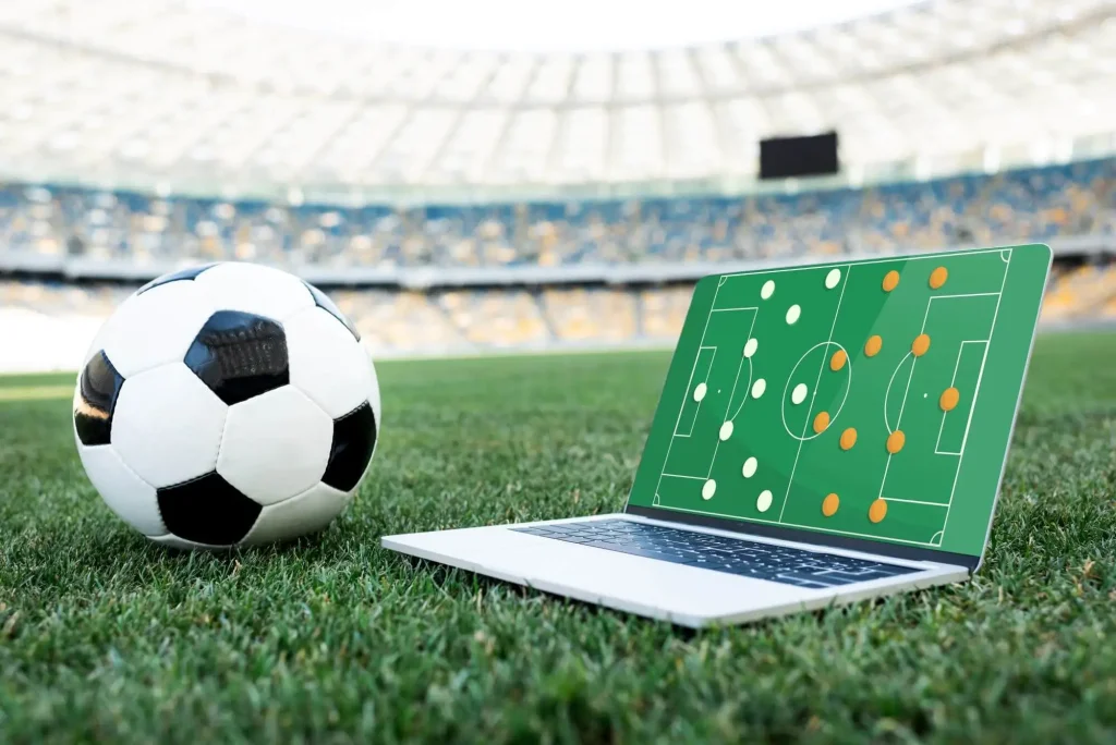 Ein Ball und Laptop auf dem Rasen eines Stadions