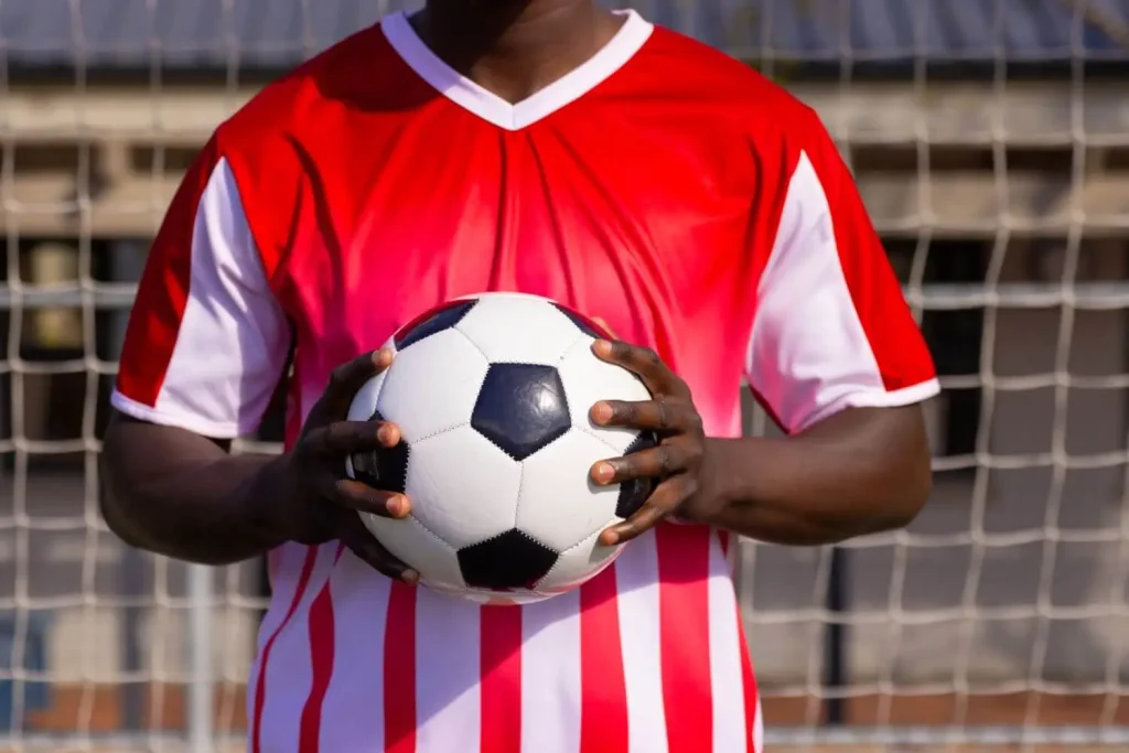 Ein Spieler hält einen Fußball