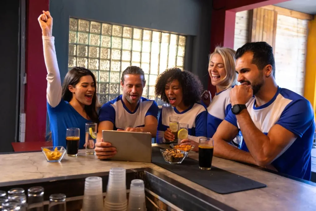 Befreundete Fans jubeln über den Sportwetten Freunde werben Bonus