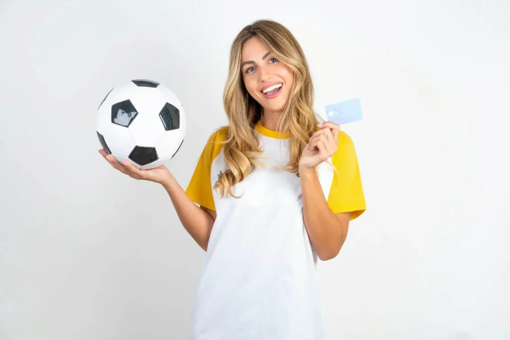 Frau mit Fußball und Kreditkarte in der Hand