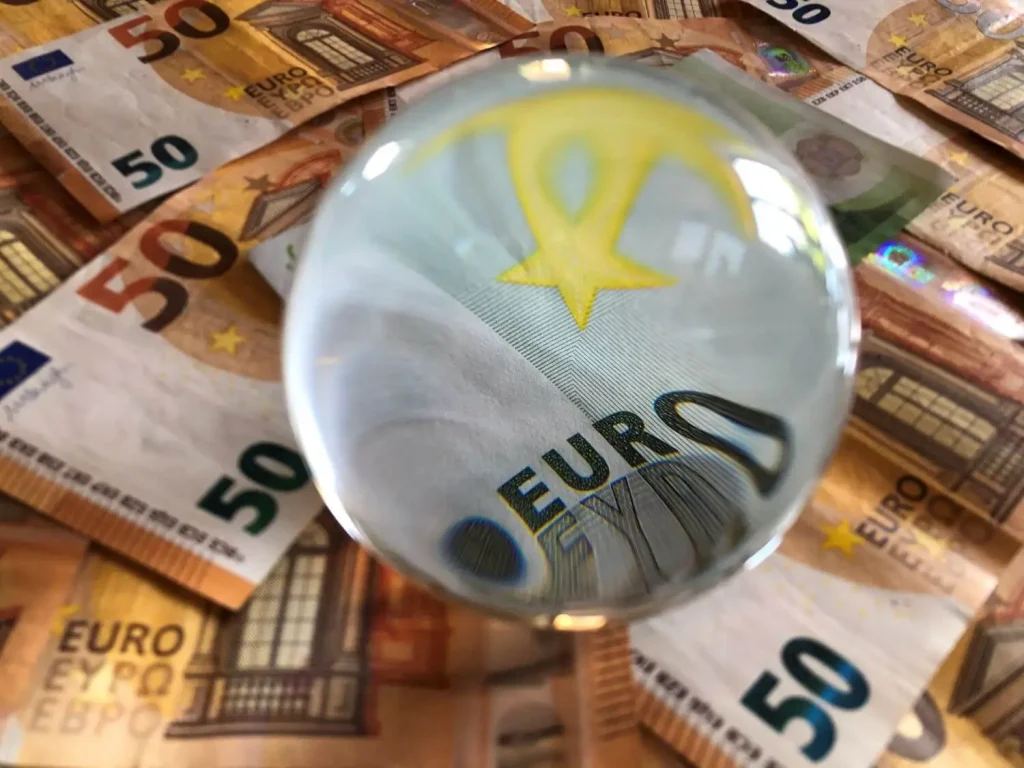 Kristallball mit Geldscheinen darunter