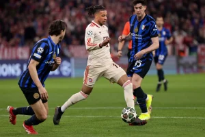 Michael Olise von Bayern München dribbelt gegen zwei Spieler von Inter Mailand