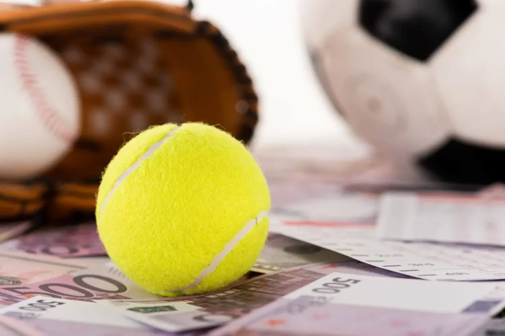 Tennisball und Fußball mit Geldscheinen
