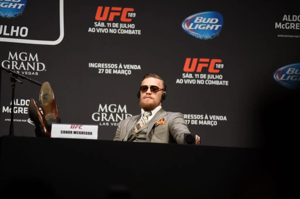 Conor McGregor, der 2026 sein Comeback geben dürfte, bei einer Pressekonferenz mit den Füßen auf dem Tisch