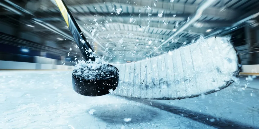 Eishockeyschläger beim Schuss mit Puck in der Nahansicht