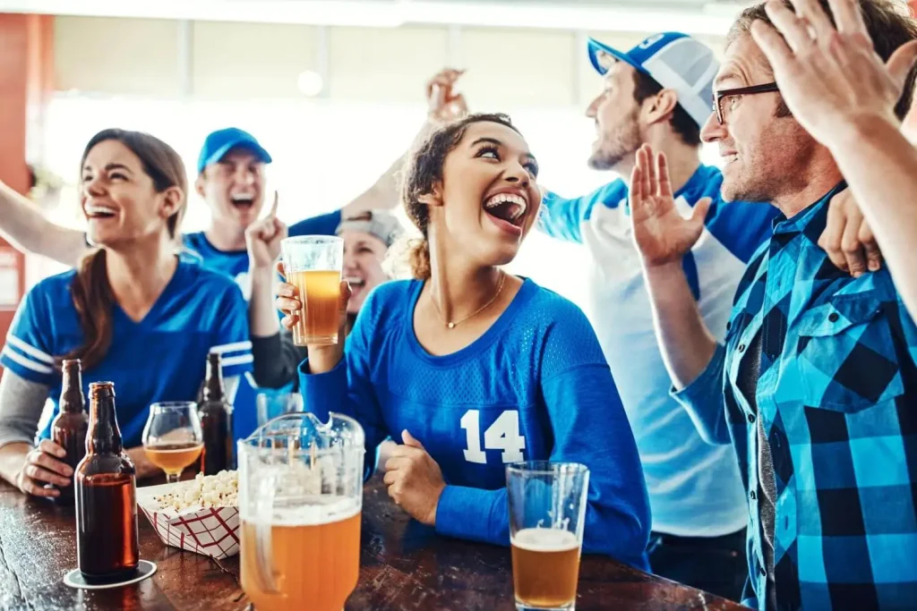 Fans feiern beim Fußballschauen in einer Bar