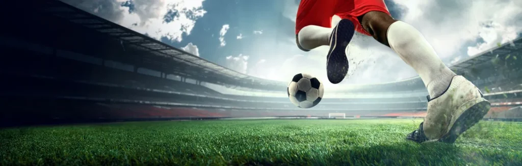 Fußballer rennt mit Ball von unten fotografiert