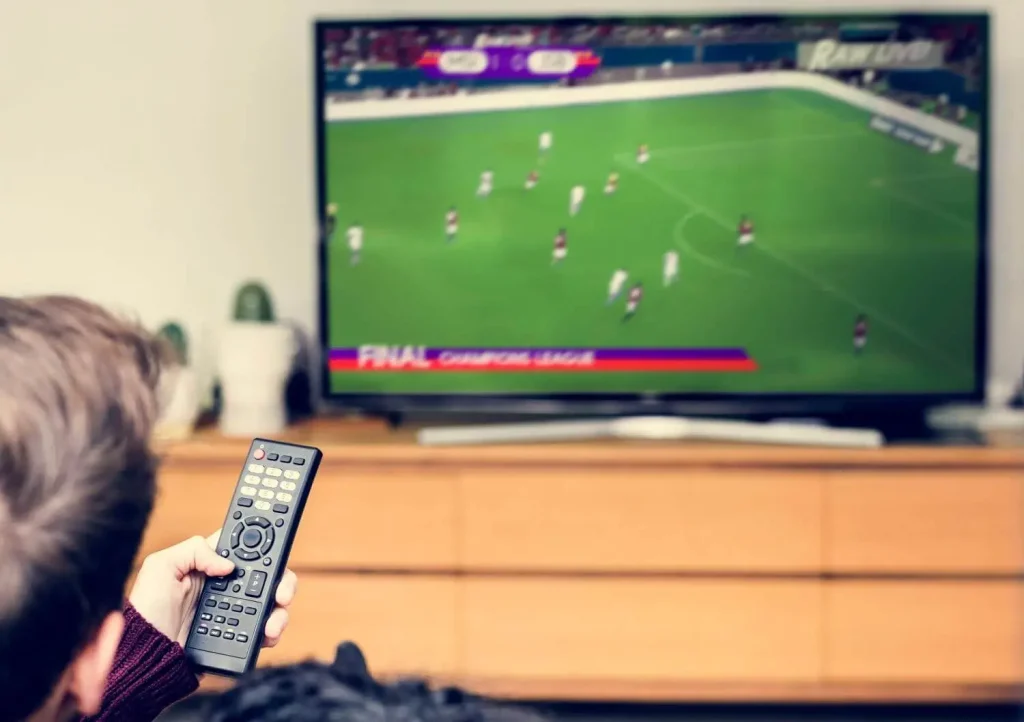 Mann schaut Fußball im TV und ärgert sich über hohe TV-Abo-Kosten