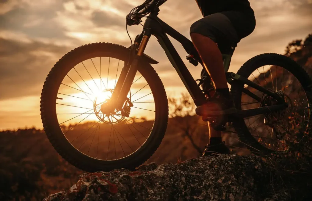 Mountainbike mit Fahrer beim Sonnenuntergang