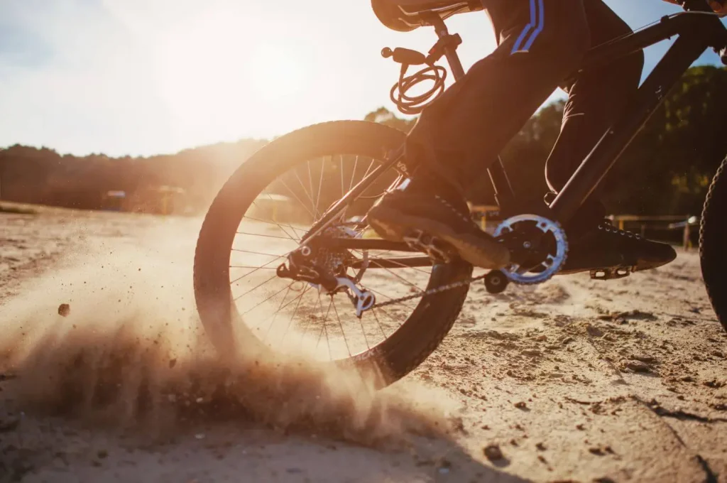 Mountainbike wirbelt in einer Kurve Staub auf