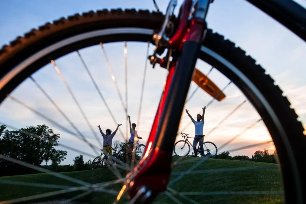 Mountainbiker jubeln mit einem Fahrrad im Vordergrund