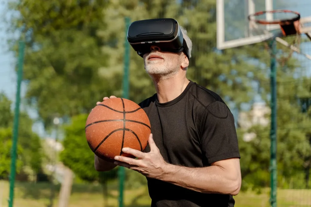 Opa mit VR-Brille hält einen Basketball