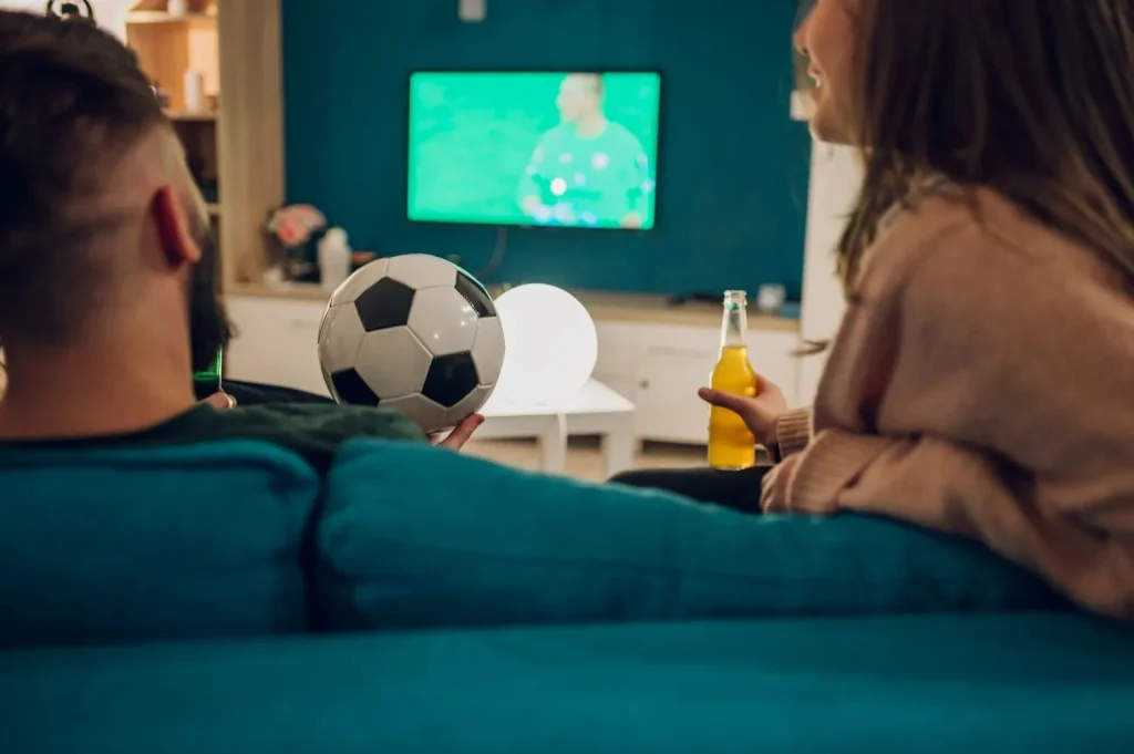 Paar schaut Fußball und trinkt Bier