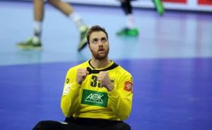 Andreas Wolff, der in Deutschland die höchsten Handball Gehälter kassiert, sitzt nach einer Parade auf dem Boden des Spielfeldes