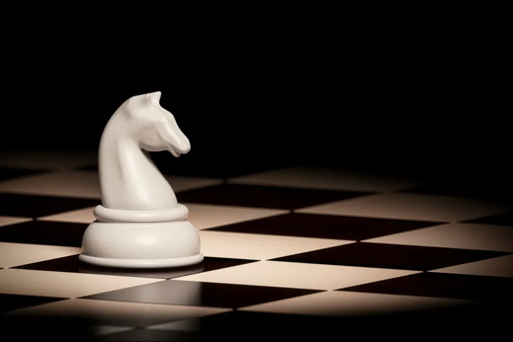 Einsame, weiße Pferd-Schachfigur auf einem Schachfeld zur Schach WM 2025