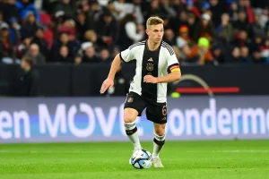 Joshua Kimmich läuft im Trikot der deutschen Fußballnationalmannschaft mit dem Fußball über das Spielfeld