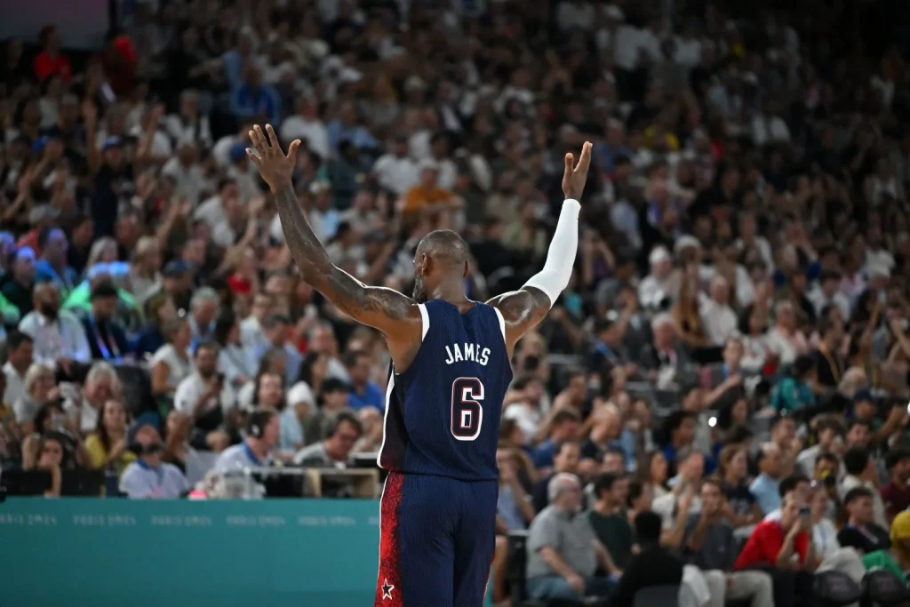LeBron James, NBA-Spieler mit den meisten Punkten aller Zeiten, hebt auf dem Spielfeld beide Arme empor