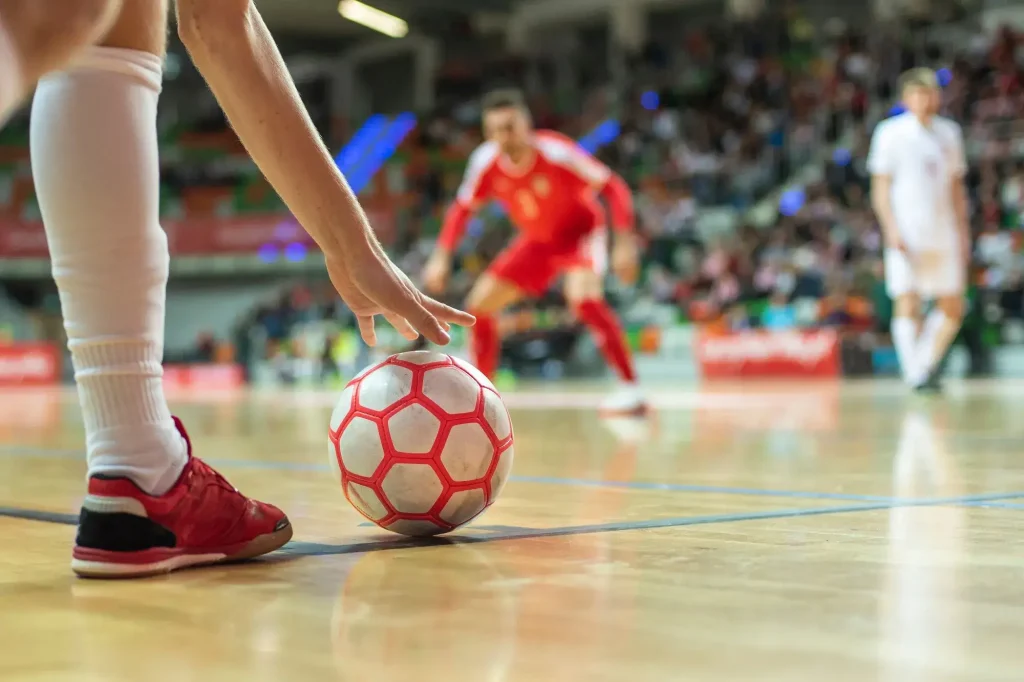 Spieler setzt bei einem Spiel fuer Futsal Livewetten zum Schuss an